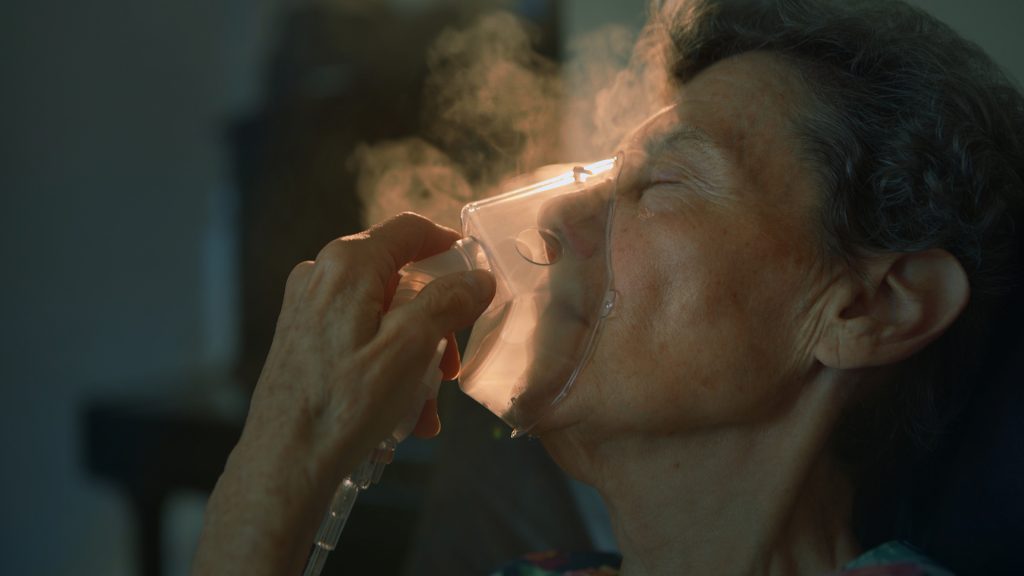 RRI Thumbnail with older lady breathing through oxygen mask.